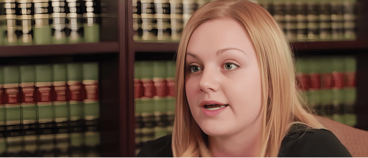 Blonde woman speaking in front of law library bookshelves