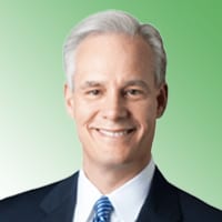 Male personal injury lawyer in suit and tie against green background