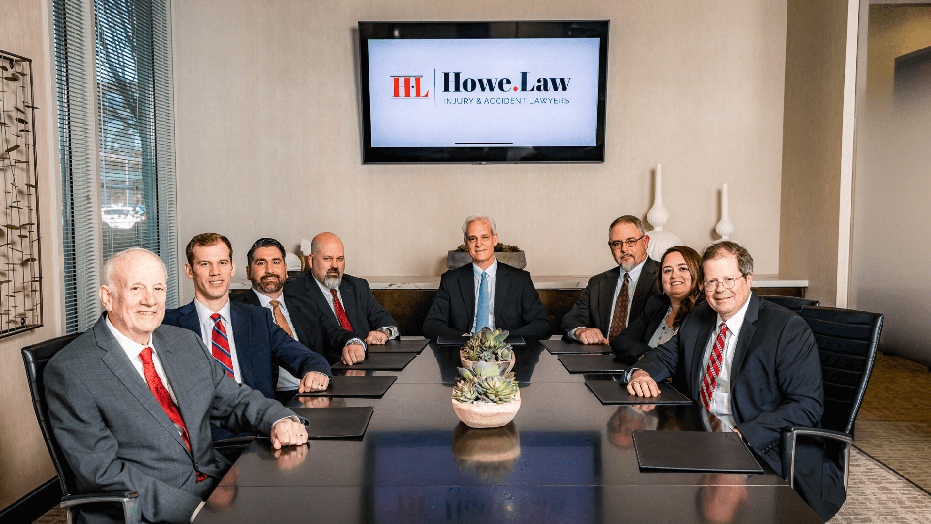 Howe Law injury and accident lawyers team seated around conference table in Atlanta office