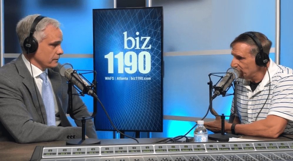 Two men with headphones discuss legal topics at Biz 1190 Atlanta radio studio