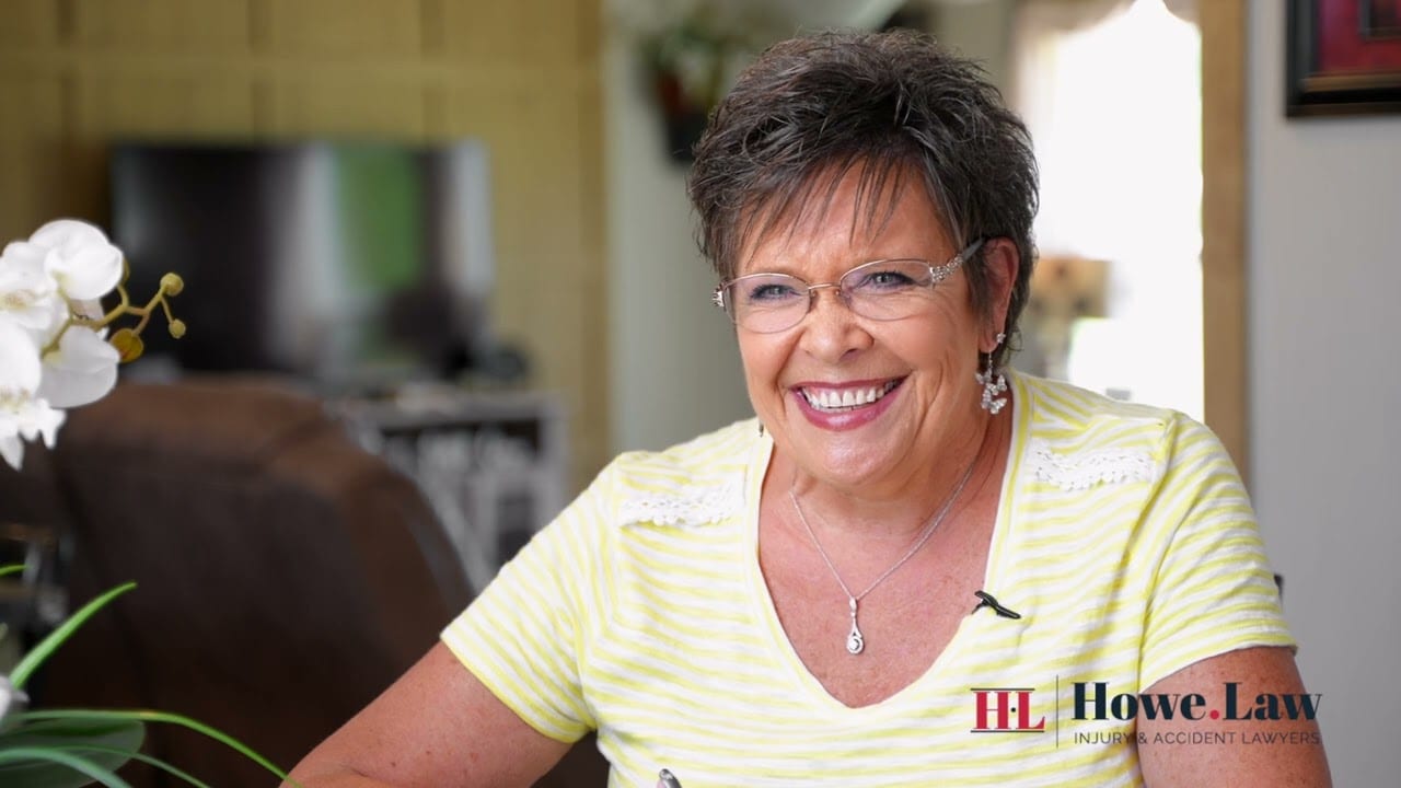 Smiling woman in yellow striped shirt shares testimonial for Howe Law